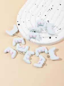 Macro shot of light blue resin game controller charms with pink buttons for DIY crafts