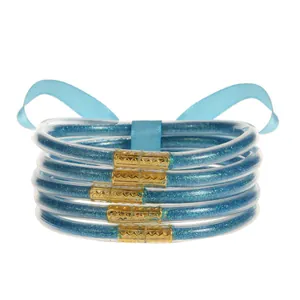 Vista detallada de pulseras de silicona con purpurina azul claro y cierres dorados grabados