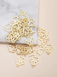 Vue détaillée de pendentifs dorés en forme de patte creuse avec anneaux de connexion
