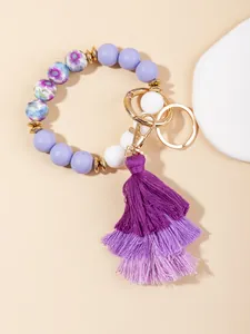 Detail of purple silicone beaded keychain with tiered fringe tassel and golden hardware
