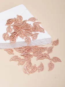 Macro detail of rose gold hollow leaf pendants for DIY jewelry making with fine texture