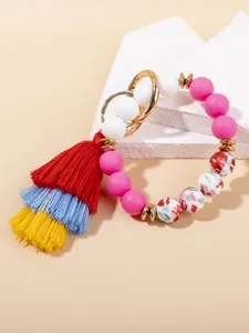 Close-up of bohemian colorful silicone bead bracelet with multi-layer tassel and gold clasp