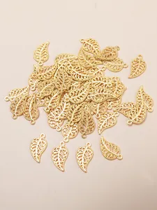 Macro detail of golden hollow leaf charms for DIY jewelry making accessories