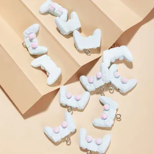 Miniature resin game controller charms in light blue and pink with metal rings for DIY