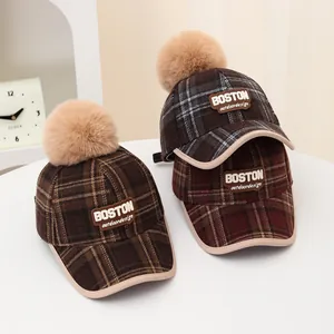 Winter plaid baseball cap with faux fur pom and Boston letter patch in warm earth tones