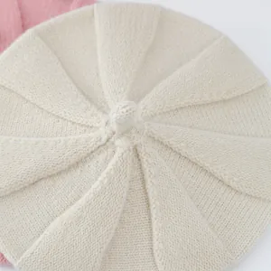 Detailed top view of a cream knitted pumpkin beret cap showing fine stitch texture