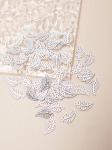 Macro shot of silver alloy leaf pendants with filigree hollow design for DIY jewelry