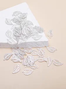 Macro shot of silver hollow leaf charms with detailed texture for DIY jewelry making