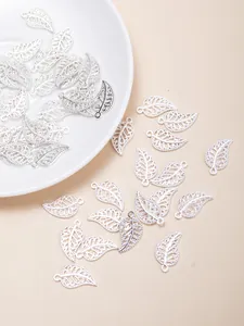 Detailed view of silver hollow leaf charms for DIY jewelry making and earring crafts