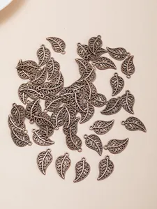 Macro shot of vintage bronze alloy leaf charms with hollow patterns for jewelry making