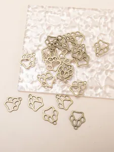 Détail de pendentifs patte en bronze sur verre ondulé pour la création de bijoux