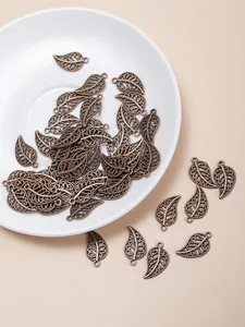 Detailed macro of hollow bronze leaf pendants and alloy jewelry DIY crafting components