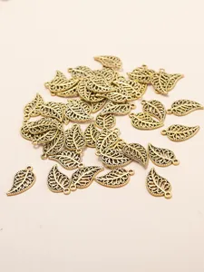 Detailed macro view of vintage gold hollow leaf alloy pendants for DIY jewelry making