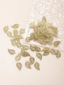 Detailed macro view of vintage gold hollow leaf charms with intricate filigree patterns