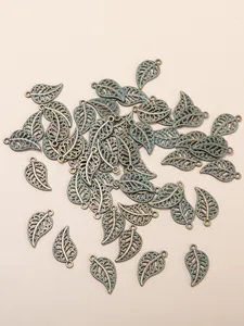 Detailed macro view of hollowed leaf-shaped antique bronze alloy charms for DIY jewelry