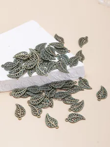 Macro detail of hollow leaf alloy pendants with green enamel finish for jewelry making