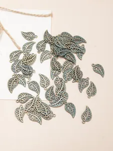 Macro view of vintage bronze leaf pendants with hollow veins and green patina finish