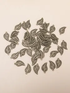 Macro detail of antique bronze alloy hollow leaf pendants for jewelry making