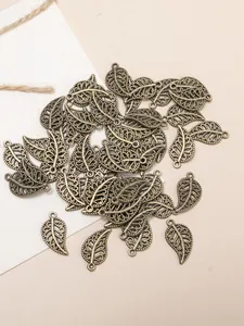 Detailed close-up of antique bronze alloy leaf pendants with intricate hollow vein textures