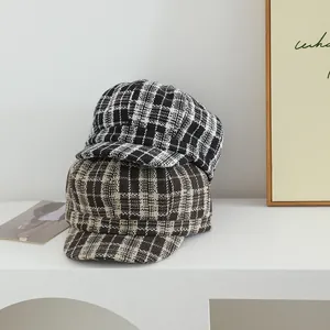Detailed view of winter wool plaid newsboy caps in classic black and brown checkered pattern