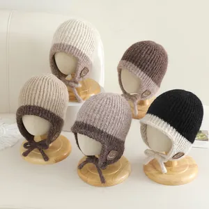 Detailoverzicht van de gebreide wintermuts voor baby's met schattige glimlachpatch