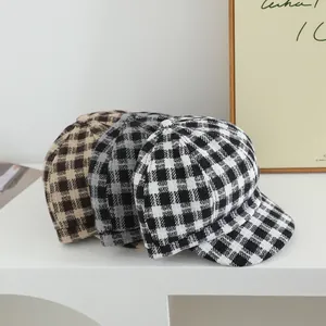 Detail of wool blend plaid newsboy caps in black, grey, and brown checkered patterns