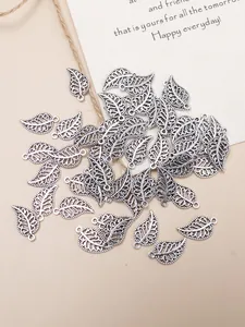 Macro detail of antique silver hollow leaf charms for jewelry making with DIY top ring hook
