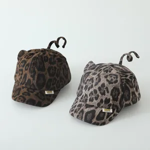 Detailed close-up of leopard print toddler baseball caps with cute 3D ears and spiral tails