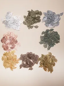 Detailed macro view of hollow leaf alloy pendants in eight various metallic finishes