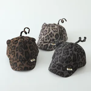 Detailed trio of leopard print toddler baseball caps with plush ears and spiral tails