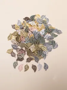 Detailed close-up of hollow leaf pendants in multiple metallic finishes for jewelry making