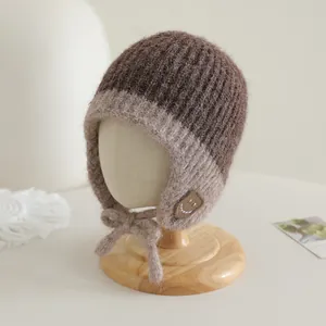 Detail van de gebreide textuur en smile-patch op deze warme wintermuts voor baby's