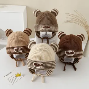 Detail of four knit baby earflap hats with striped bear ears and soft warm lining