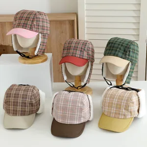 Detailed view of checkered winter trapper hats with warm faux wool lining and earflaps