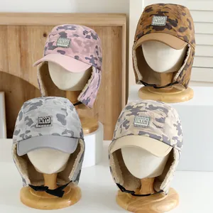 Detailed view of kids camo winter earflap hats with NYC embroidery and faux fleece lining