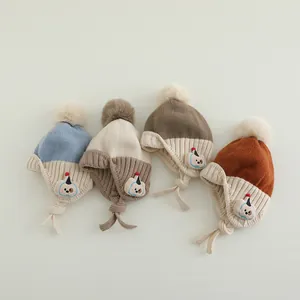 Gestrickte Baby-Wintermütze mit Ohrenklappen, Bommel und niedlichem Hunde-Aufnäher
