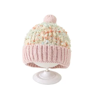 Winterse gebreide babymuts met kleurrijke pompon en zachte oorbescherming voor peuters