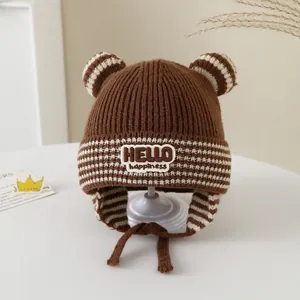 Close-up of brown baby winter knit hat with earflaps, stripes, and cute ear details