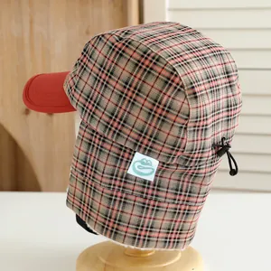Detail of plaid winter hat showing adjustable drawstring and warm white fleece lining