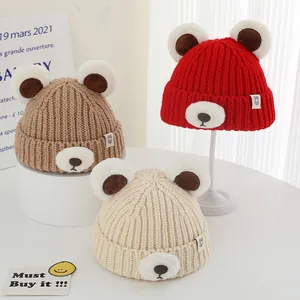 Winter knitted baby bear hat with plush ears in brown, red, and cream white colors