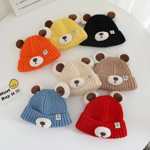 Close-up of knit baby bear beanies in vibrant colors with cute 3D ears and badges
