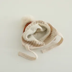 Detailansicht der warmen Baby-Strickmütze mit Pompon und weichem Fleece-Innenfutter