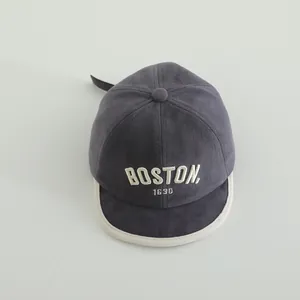 Detailed macro view of dark grey cotton baseball cap with white BOSTON embroidery
