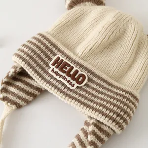 Close-up of baby winter knit hat featuring cute ears and HELLO happiness patch detail