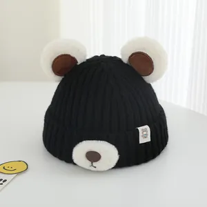 Detail of cute bear ears and plush snout on a black knit winter beanie for kids
