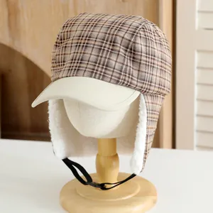 Detailed view of winter plaid trapper hat with warm white fleece lining and adjustable strap