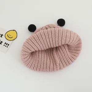 Gros plan du bonnet en tricot rose pour enfant avec de mignons pompons oreilles noirs