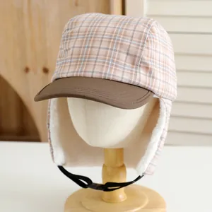 Detail of warm winter trapper hat with plaid pattern and soft white faux fur lining
