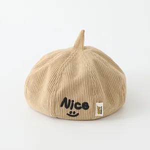 Nahaufnahme der hellbeigen Cord-Baskenmütze für Kinder mit Nice-Smiley-Stickerei