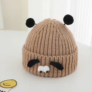 Détail du bonnet en maille pour enfant avec oreilles de chien et texture côtelée douce